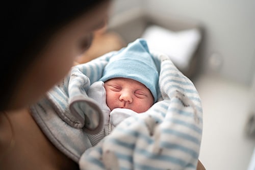 Adoptive mother admiring her newborn son at the hospital