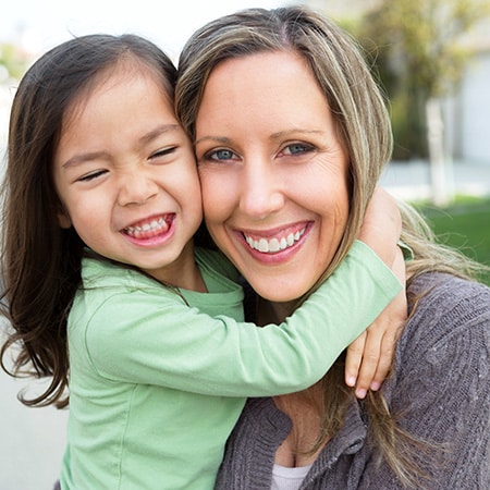 woman hugging her internationally adopted child