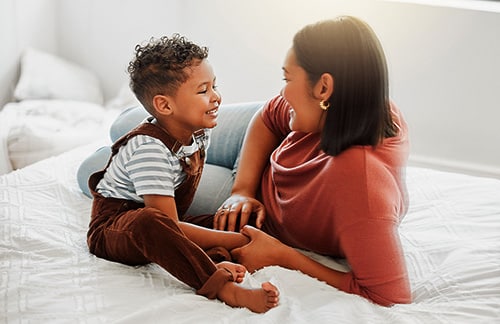 Loving and caring mother talking with  her toddler son about adoption